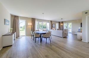 a living room with a table and chairs and a couch at Strandliebe - 5 Sterne Ferienwohnung - Urlaub zwischen Ostsee und Bodden in Wustrow