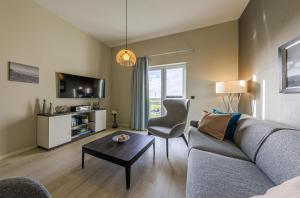 a living room with a couch and a table at Francis Drake Suite - 5-Sterne Wellnessurlaub mit Ostseeblick in Wustrow