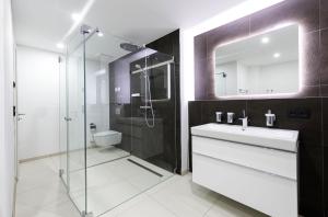 a bathroom with a sink and a glass shower at Strandliebe - 5 Sterne Ferienwohnung - Urlaub zwischen Ostsee und Bodden in Wustrow +18 photos
