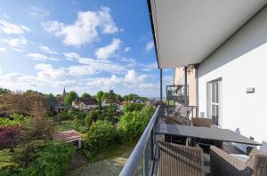 a balcony with chairs and a view of a city at Boddentraum - 5 Sterne Ferienwohnung mit Blick auf das malerische Ostseebad Wustrow in Wustrow