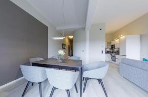 a kitchen and dining room with a table and chairs at Boddentraum - 5 Sterne Ferienwohnung mit Blick auf das malerische Ostseebad Wustrow in Wustrow