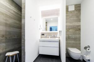 a bathroom with a white sink and a toilet at Boddentraum - 5 Sterne Ferienwohnung mit Blick auf das malerische Ostseebad Wustrow in Wustrow +20 photos