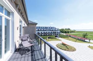 a balcony with a chair and a building at Ostsee-Schönheit Wustrower Welle-Modernes 2-Zimmer-Apartment mit Panoramablick in Wustrow
