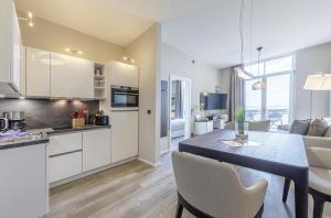 a kitchen and living room with a table and chairs at Kleine Welle - Haustierfreundliches Zwei-Zimmer Apartment mit Südbalkon und Platz für drei Personen im ersten Obergeschoss in Wustrow +13 photos