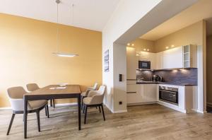 a kitchen and dining room with a table and chairs at Ostseeglück - 5-Sterne-Ferienwohnung mit Südbalkon und Blick zum Saaler Bodden in Wustrow
