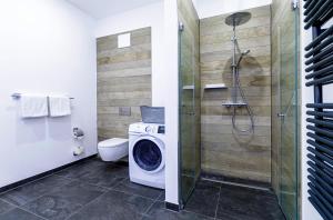 a bathroom with a washing machine and a shower at Ostseeglück - 5-Sterne-Ferienwohnung mit Südbalkon und Blick zum Saaler Bodden in Wustrow +14 photos