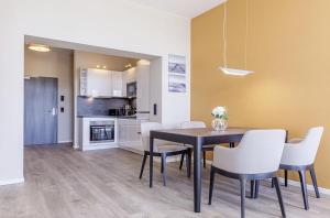 una cucina e una sala da pranzo con tavolo e sedie di Ostseefeeling - 5 Sterne Ferienwohnung mit Südbalkon in der Seefahrtschule Wustrow a Wustrow