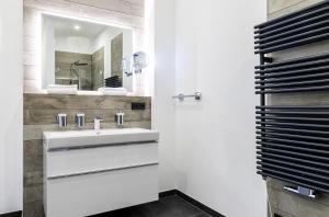 un bagno con lavandino e specchio di Ostseefeeling - 5 Sterne Ferienwohnung mit Südbalkon in der Seefahrtschule Wustrow a Wustrow Altre 17 foto