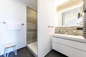 a bathroom with a sink and a mirror at Seebadperle - 5 Sterne Ferienwohnung - Exklusives Ambiente zwischen Ostsee und Bodden in Wustrow +19 photos