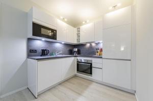 a kitchen with white cabinets and stainless steel appliances at 5 Sterne Ferienwohnung Boddenzauber in ruhiger Lage mit traumhaftem Ausblick in Wustrow