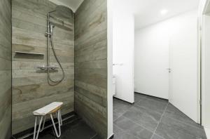 a bathroom with a shower and a stool at Marco Polo Suite - Komfort und Erholung zwischen Ostsee und Bodden in Wustrow +23 photos