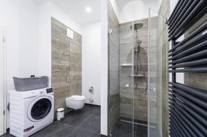 a bathroom with a washing machine and a toilet at Tolle 5 Sterne Ferienwohnung Ostseequartier mit dem wunderschönem Südbalkon in Wustrow +22 photos