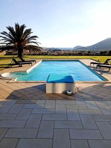 a large swimming pool with two benches around it at Villa Andros, Beauty and Luxury - Private Pool in Andros