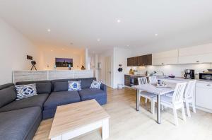 Nordlicht - Modernes Apartment auf Seegrundstück في مالتشو: غرفة معيشة مع أريكة وطاولة ومطبخ