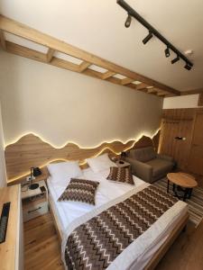 Apartment Vucko C030 Jahorina private host Aparthotel Vucko في ياهورينا: غرفة نوم بها سرير كبير وأريكة +19 صورة