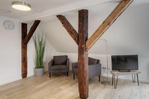un soggiorno con travi in legno, TV e sedia di City Suite an der Drehbrücke Malchow a Malchow