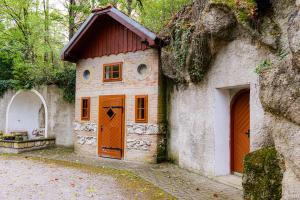 a small house with orange doors on the side of a building at Villa Rose close to Vienna & Airport in Maria Ellend