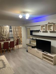 a living room with a television and a table and chairs at Strada calea unirii bloc 5 in Craiova