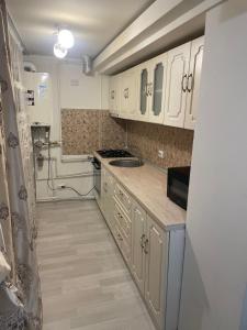 a kitchen with white cabinets and a sink at Strada calea unirii bloc 5 in Craiova
