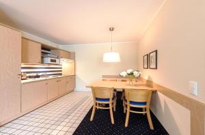 a kitchen with a wooden table and chairs at Strandhafer an der Seebrücke in Zingst
