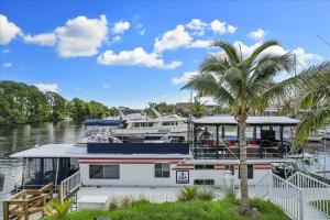 a boat docked in a marina with a palm tree at Unique Houseboat Rental in Merritt Island
