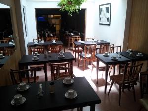 a dining room with black tables and wooden chairs at Hotel Europa in Mar del Plata