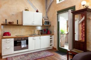 a kitchen with white cabinets and a sink at Rapunzel - Gemütliche Ferienwohnung mit Landhausstil und überdachtem Balkon in Waren