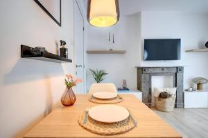 a dining room with a table and a fireplace at - Le Cocoune - Cosy & Cute Flat in Liège