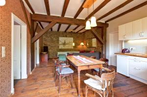 a kitchen and dining room with a wooden table and chairs at Ferienwohnung Lilie mit Balkon in einer geschmackvoll sanierten Backsteinmühle in Waren