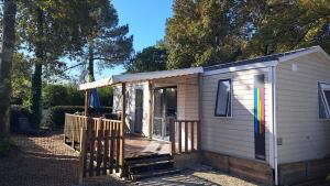 拉特斯特德布赫Mobil home Domaine de la Forge的一间白色的小小屋,设有门廊和门