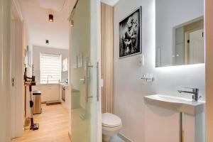 a white bathroom with a toilet and a sink at - Le Cocoune - Cosy & Cute Flat in Liège