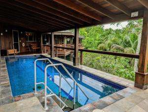 a swimming pool with a view of a house at Villa Divina at Framadani estate - Jungle villa with a pool in San Ignacio