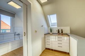 ein Bad mit weißen Schränken, einem Waschbecken und einem Fenster in der Unterkunft Ferienhaus Casa Castagno mit Garten, Balkon und Sauna- heißt Sie herzlich willkommen! in Alt Schwerin + 17 Fotos