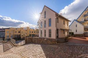 a building on a cobblestone street in a city at Ferienwohnung Siegel am Müritzufer in Waren