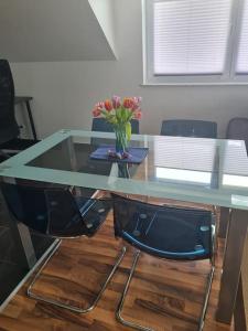 a glass table with a vase of flowers on it at Schöne Wohnung in idyllischer Lage in Biberach an der Riß