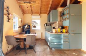 a kitchen with a wooden table and a dining room at Blau am See -Ihr Ferienhaus am Jabelschen See in Jabel +12 photos