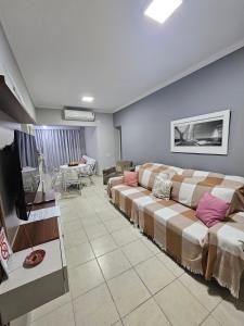 a living room with couches and a television at Flat Golden Beach Pitangueiras Apartamento in Guarujá