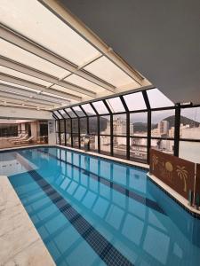 a large swimming pool with a view of the city at Flat Golden Beach Pitangueiras Apartamento in Guarujá