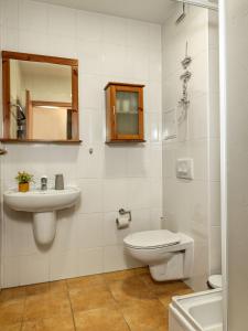 a white bathroom with a toilet and a sink at Ostseeblick in Kirchdorf