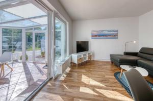 a living room with a couch and a tv at Ferienhaus Eddi am Tiefwarensee in Waren