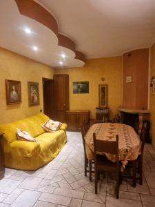 a living room with a yellow couch and a table at La Torre di cry & cry in Magenta