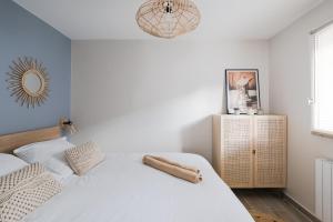a bedroom with two white beds and a mirror at Central appartement with terrace and free parking in Deauville