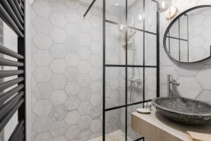 a bathroom with a stone sink and a mirror at Central appartement with terrace and free parking in Deauville