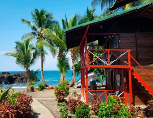 a resort on the beach with palm trees and the ocean at Hotel Nautilos Nuquí in Nuquí