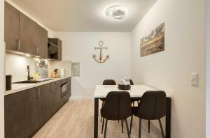 a kitchen with a table and chairs in a room at Ostseeschatz - Moderne Ferienwohnung im malerischen Ostseebad Zingst in Zingst