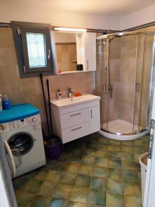 a bathroom with a shower and a sink and a washing machine at Grey house in Samos +29 photos
