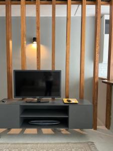 TV de pantalla plana en la parte superior de un centro de entretenimiento en Elegante y confortable Departamento Mitre, en Esquina