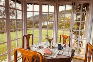 a table in a room with a large window at Stumpfields in Ooty
