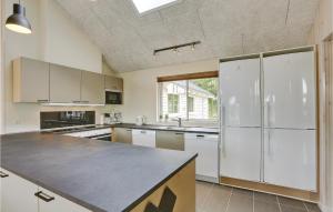 a kitchen with white cabinets and a counter top at Cozy Home In Vejby With Sauna in Vejby