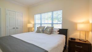 Kendal GreenSpacious Apt with Pool的一间卧室，有一张床，两盏灯和一扇窗户